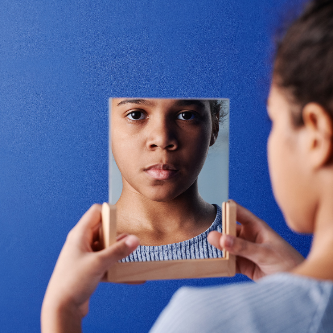 Young girl looks in mirror, menstrual hygiene, child marriage