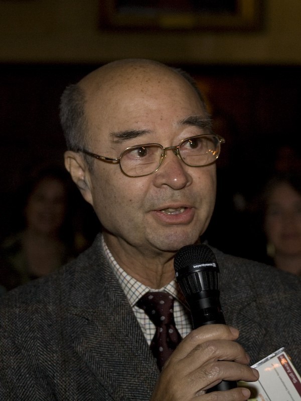 Mechai Viravaidya speaking into a microphone at the 2008 Skoll World Forum.