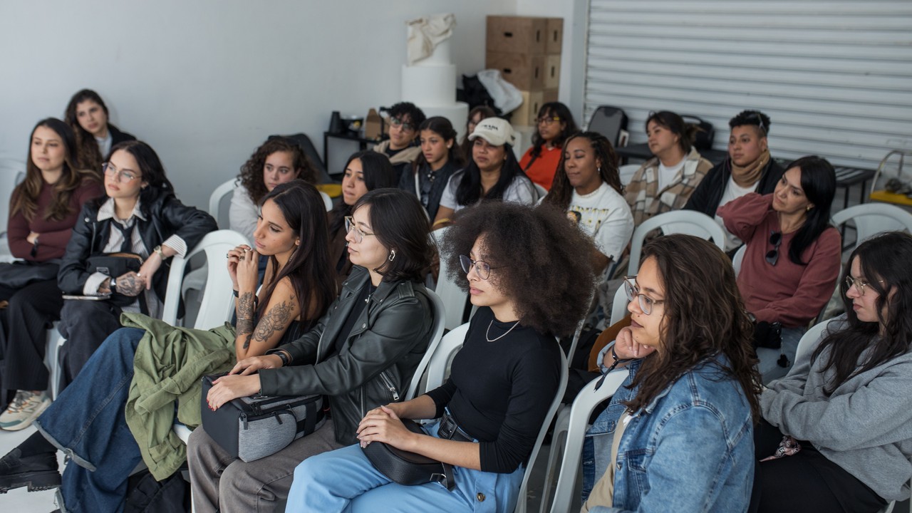 A group of adults sit together and listen during a workshop.